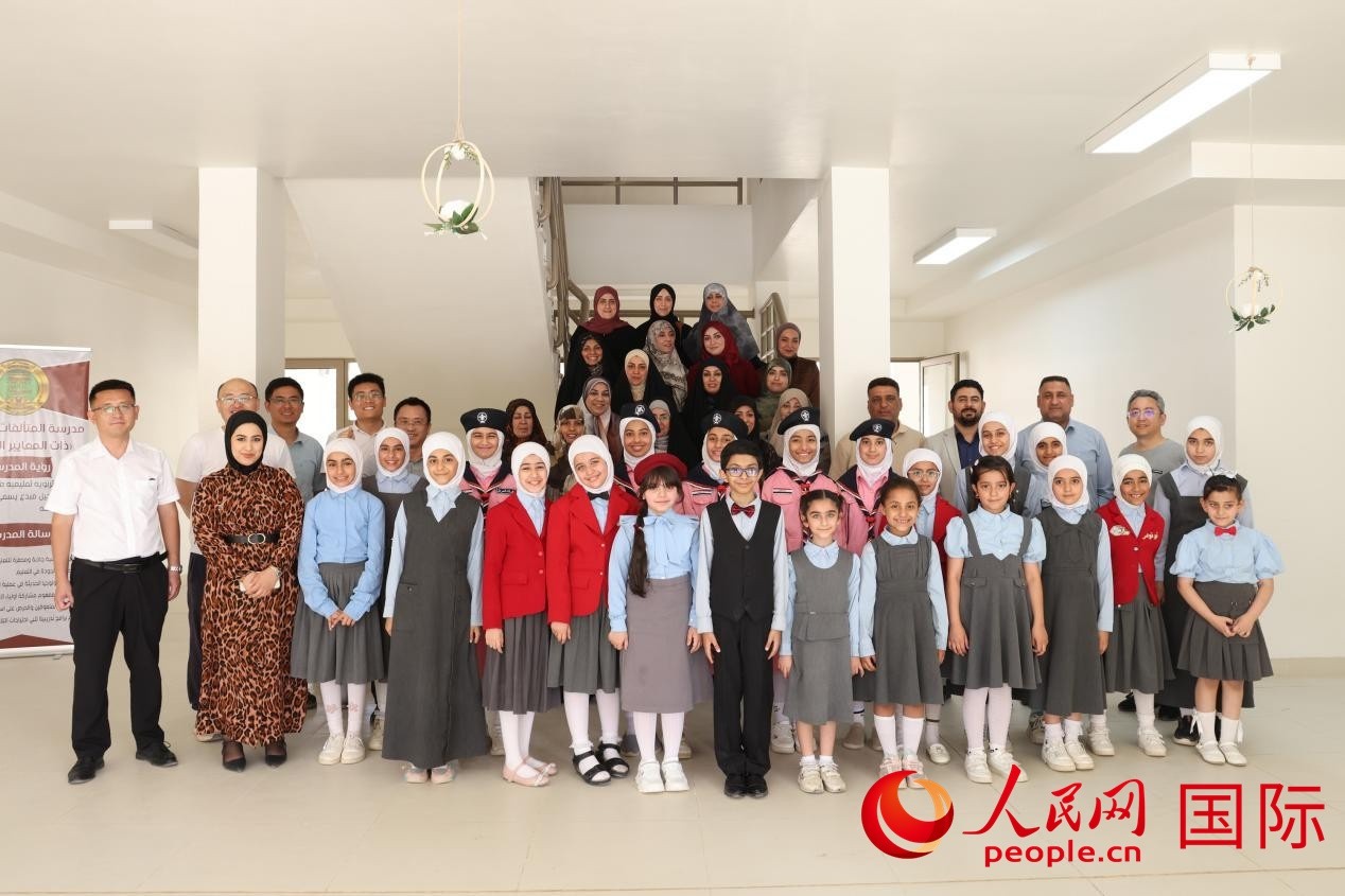 中國電建員工與阿爾穆塔?阿里卡特國際學(xué)校的師生及政府官員等合影。人民網(wǎng)記者 薛丹攝