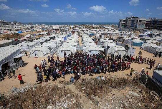 5月28日，人們?cè)诩由吵俏鞑康纳程犭y民營等待領(lǐng)取救助食物。新華社發(fā)（里澤克·阿卜杜勒賈瓦德攝）