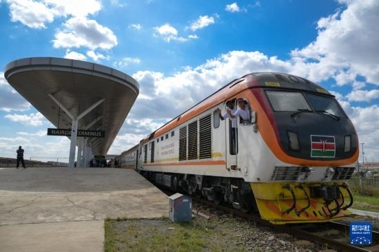 5月31日，在蒙內(nèi)鐵路內(nèi)羅畢站，機車駕駛員蔣立平（右）和博爾在即將開往蒙巴薩的E2次列車上揮手致意。新華社記者 楊光 攝