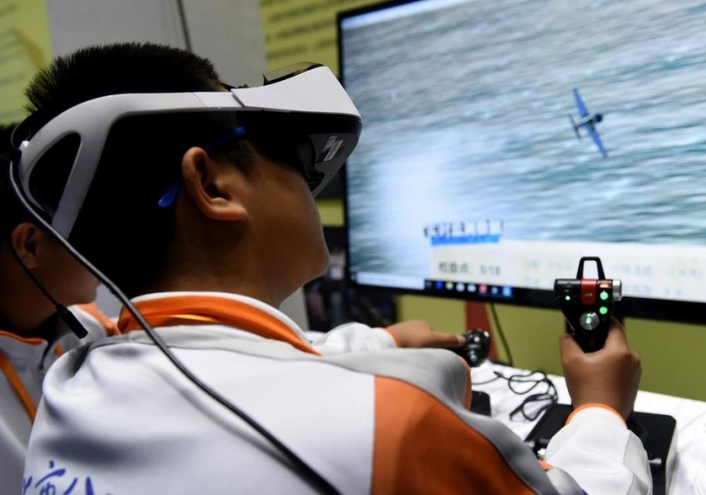 北京市八一學(xué)校的學(xué)生在北京市中小學(xué)生特色科技活動(dòng)展示上體驗(yàn)VR技術(shù)（2018年11月24日攝）新華社記者 羅曉光 攝。